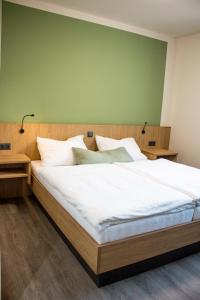 a bedroom with a large bed with a green wall at Bärenhof in Matzen