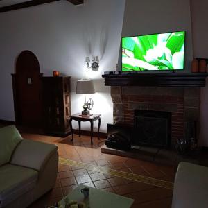 a living room with a tv on top of a fireplace at Casa Vale da Serra - Petrópolis in Petrópolis