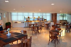 a restaurant with tables and chairs and a bar at Ville Celestine Hotel in Belo Horizonte