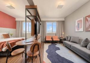 a hotel room with a bed and a couch at Intercity Porto Alegre Cidade Baixa in Porto Alegre