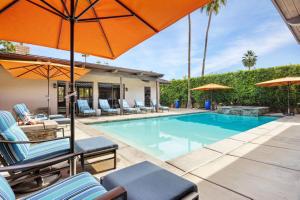 a swimming pool with chairs and umbrellas at Desert Solstice in Palm Springs +45 photos