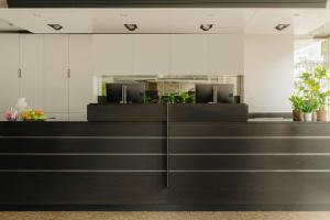 a reception desk in a office with plants at Leonardo Hotel Eindhoven City Center in Eindhoven