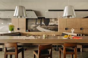 a kitchen with a large wooden table and chairs at Leonardo Hotel Eindhoven City Center in Eindhoven