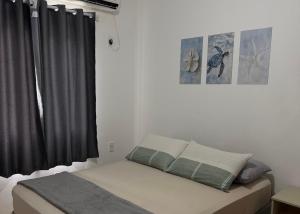 a bedroom with a bed with a black curtain at Apartamento Sunset 101 in Palhoça