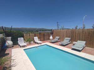 a swimming pool with lounge chairs at miradas serranas 2 in Villa Giardino