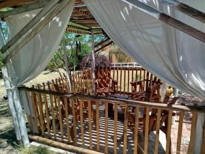 a wooden deck with chairs and a canopy at miradas serranas 2 in Villa Giardino