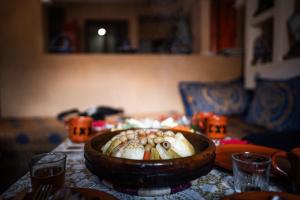 a table with a bowl of food on a table at Toubkal Guesthouse in Imlil