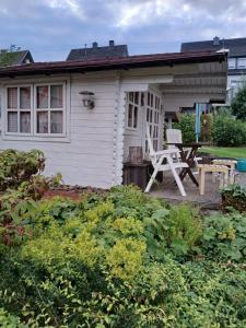 a white house with a table and a chair on the porch at Ferienwohnungen Rump in Hilchenbach
