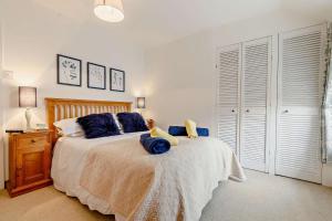 a bedroom with a large bed with blue pillows at 2 Bed in St. Minver oc-p27580 in Saint Minver