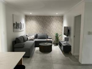 a living room with a couch and a brick wall at The Tarp at Whale Cove in De Kelders