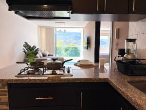 a kitchen with a stove with pots and pans on it at Espacio cómodo, piscina, jacuzzi y parqueadero in San Gil