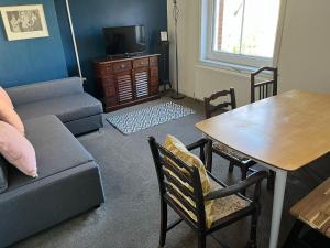 a living room with a couch and a table at Corner House Apartment in Worthing