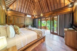 a bedroom with a large bed in a room at Saughina Ubud in Ubud