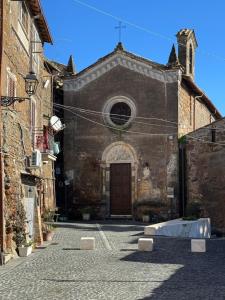an old church with a wooden door in a street at NEpicentro2 in Nepi