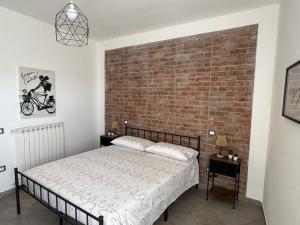 a bedroom with a brick wall and a bed at NEpicentro2 in Nepi