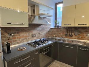 a kitchen with a stove top oven next to a sink at NEpicentro2 in Nepi