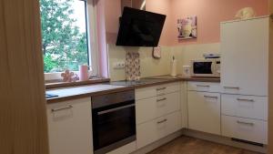 a kitchen with white cabinets and a window at Ferienwohnungen Rump in Hilchenbach +21 photos