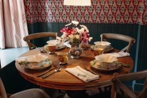 a wooden table with a vase of flowers on it at Muir Cottage in Aboyne