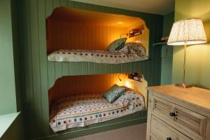 a bedroom with a bed in a green wall at Muir Cottage in Aboyne