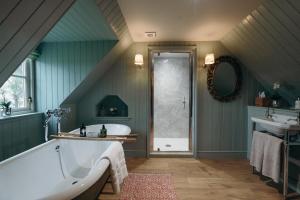a large bathroom with a tub and a sink at Muir Cottage in Aboyne