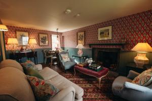 a living room with a couch and a fireplace at Muir Cottage in Aboyne