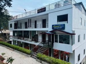 a white building with a sign on it at Jamunas B&B in Shimla