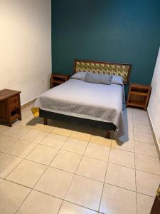a bedroom with a bed and a tiled floor at Hotel las Orquideas in Valle de Bravo +3 photos