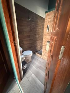 a small bathroom with a toilet and a door at Hotel las Orquideas in Valle de Bravo