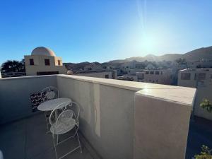 two chairs on a balcony with a view of a city at סוויטת ארגמן in Beʼer Ora