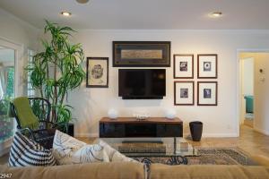a living room with a couch and a flat screen tv at Maison du Soleil in Palm Springs