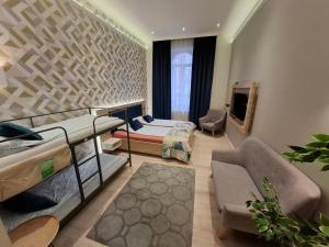 a room with a bed and a couch and a tv at Révay 6 Suites by Corall in Budapest