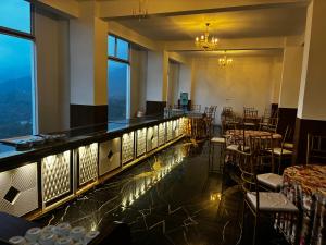 a restaurant with a bar with tables and chairs at Jamunas B&B in Shimla