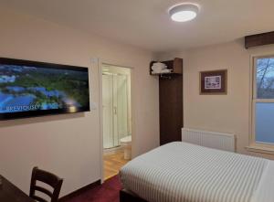 a bedroom with a bed and a flat screen tv at Woodside House in Aberdeen
