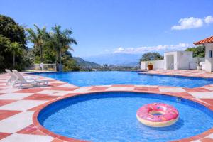 a large swimming pool with a donut in the water at Espacio cómodo, piscina, jacuzzi y parqueadero in San Gil
