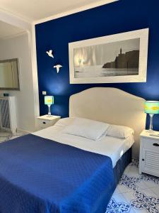 a blue bedroom with a bed with a blue wall at CASA SOFIA in Anacapri