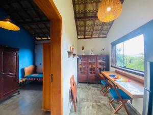 a room with a table and chairs and a window at Chalé com Jacuzzi vista para Pico da Lapinha in Santana do Riacho