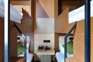 a bunk bed room with two bunk beds and a desk at A Hotel Farrer Park - Newly Renovated in Singapore