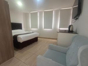 a bedroom with a bed and a chair in a room at Hotel Cortaderas Arequipa in Yanahuara