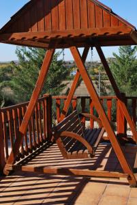 a wooden chair sitting on a porch swing at Casa Telma in Alcañiz