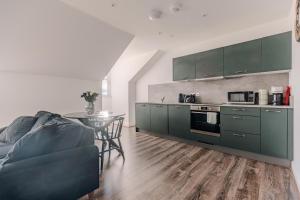 a kitchen with green cabinets and a table at Barnet House Serviced Apartments in Dunfermline