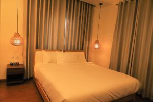 a bedroom with a large white bed with two lights at Le Casa Villa by hotel travel inn in Pokhara +18 photos