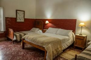 a bedroom with two beds and a brick wall at La estancia Yapeyú in Yapeyú