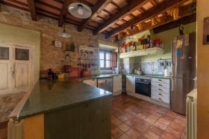a large kitchen with a large counter and a refrigerator at Cal París Rural in La Donzell D'Urgell