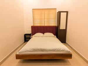 a bedroom with a bed with a wooden headboard at Mamoksha Riverdale in Padinjarathara