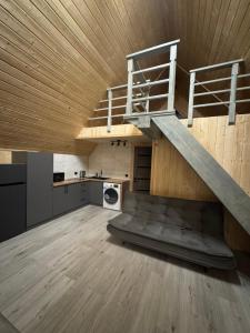 a loft with a staircase in a room with a kitchen at Dukaty House 2 in Verkhovyna +37 photos