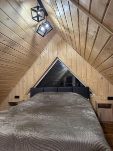 a bed in a room with a wooden ceiling at Dukaty House 2 in Verkhovyna