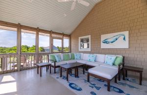 a living room with a couch and tables and windows at Shore Enough - Duck, Sanderling, 50 Yds to Beach, Elevator, Pets OK, Community Pool, Flex Stays in Duck