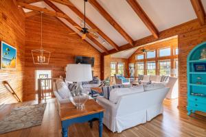a living room with white furniture and wooden walls at Shore Enough - Duck, Sanderling, 50 Yds to Beach, Elevator, Pets OK, Community Pool, Flex Stays in Duck
