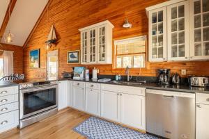 a kitchen with white cabinets and a wooden wall at Shore Enough - Duck, Sanderling, 50 Yds to Beach, Elevator, Pets OK, Community Pool, Flex Stays in Duck