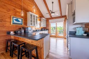 a kitchen with wooden walls and a counter with stools at Shore Enough - Duck, Sanderling, 50 Yds to Beach, Elevator, Pets OK, Community Pool, Flex Stays in Duck